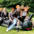 Teilnehmer auf einer aufblasbaren Teamraupe beim Teambuilding für Firmenevents, Sommerfeste und aktive Gruppenspiele im Outdoor-Bereich.
