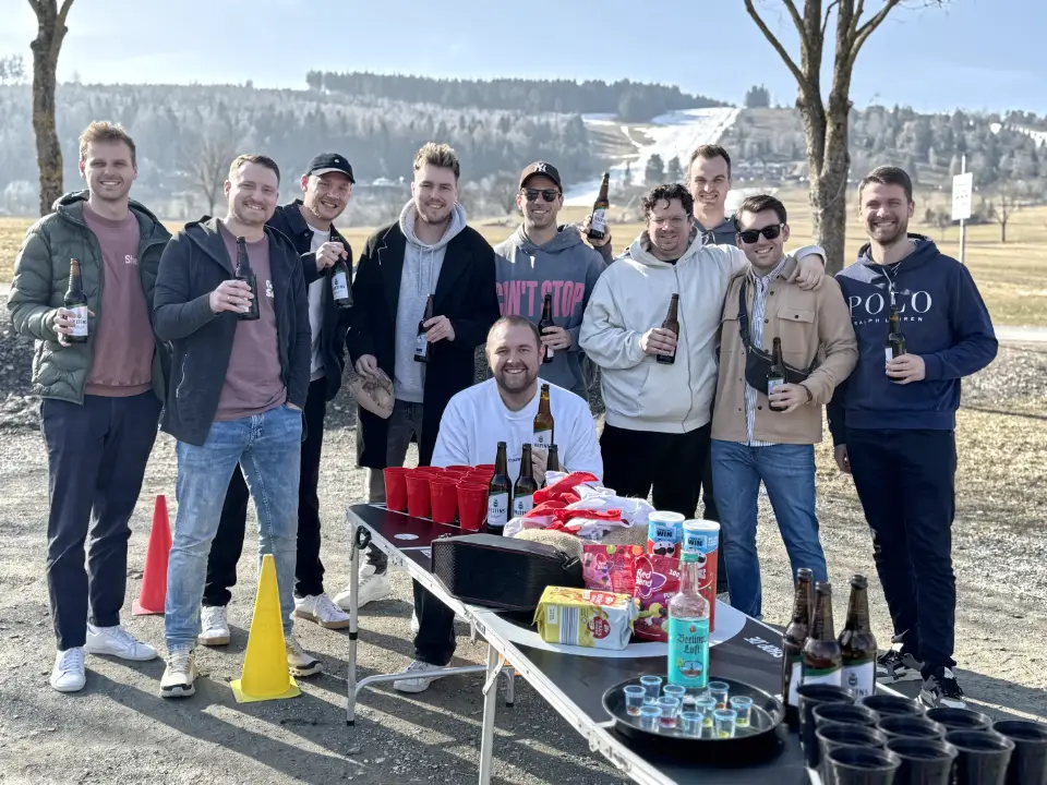 Männergruppe bei einer JGA Bierwanderung in Willingen mit Bierpong-Tisch, Bierflaschen und Outdoor-Spielstation während einer Bier Rallye.