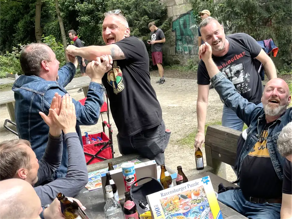 Männergruppe bei einer JGA Bierwanderung in Willingen während der Spielstation Puzzle-Weltmeister mit Bier, Team-Challenge und guter Stimmung.