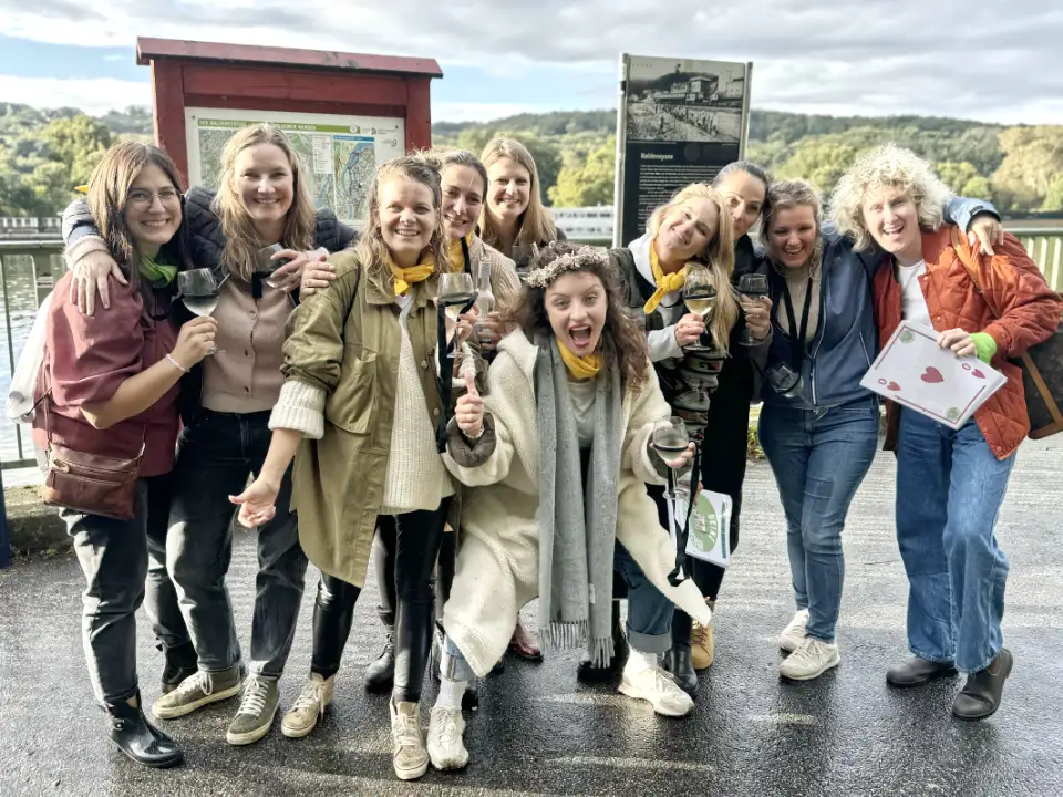 Frauen bei einem Junggesellenabschied (JGA) bei einer Weinwanderung am Baldeneysee in Essen mit Weingläsern