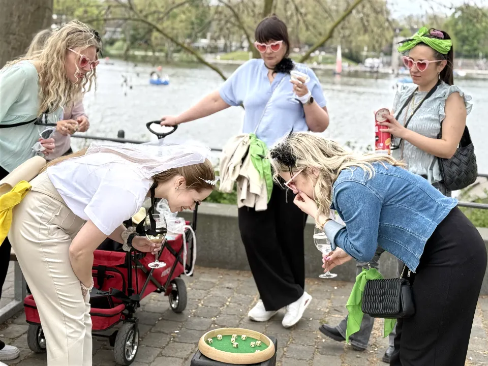 Junggesellenabschied in Münster bei einer Weinwanderung am Aasee – JGA-Gruppe duelliert sich bei einem Teamspiel der Weinrallye um Punkte.