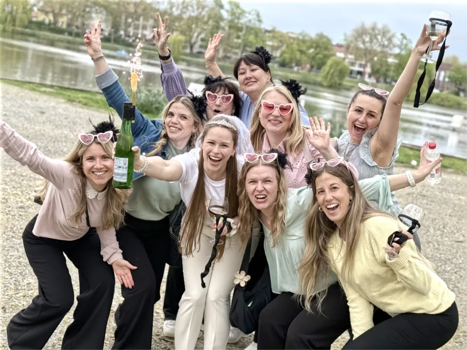 Fröhlicher Junggesellenabschied bei einer Weinwanderung in Münster mit Weinrallye am Aasee – JGA Gruppe mit Braut beim stilvollen Weinerlebnis.