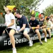 Teilnehmer nutzen eine aufblasbare Teamraupe bei einem Sommerfest und Firmenevent für Teambuilding, Teamgeist und gemeinsame Teamspiele.