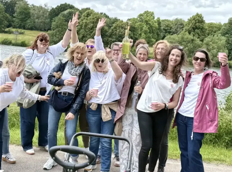 JGA Weinwanderung Münster am Aasee – Fröhliche Junggesellinnen bei der Weinrallye Junggesellinnenabschied in Münster bei einer Weinwanderung am Aasee – fröhliche JGA-Gruppe mit Wein und Spielen während der Weinrallye