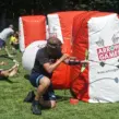 Mitarbeiter spielt Arrow Tag beim Teambuilding für Unternehmen und nutzt aufblasbare Hindernisse als Deckung auf dem Spielfeld