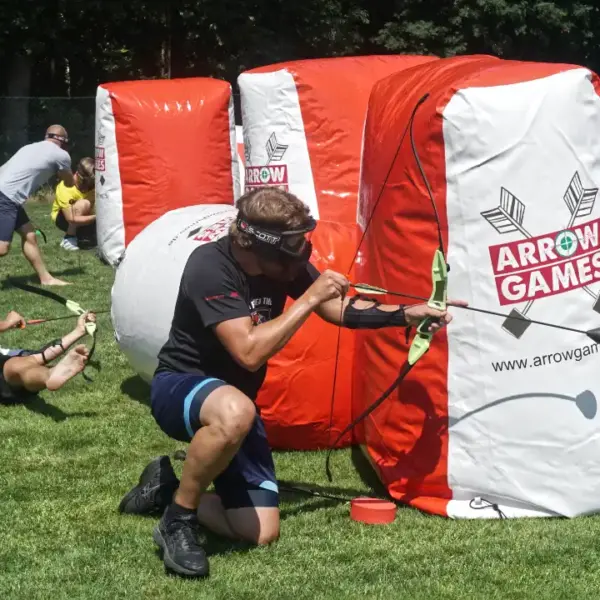Arrow Tag Teambuilding für Unternehmen Mitarbeiter spielt Arrow Tag beim Teambuilding für Unternehmen und nutzt aufblasbare Hindernisse als Deckung auf dem Spielfeld