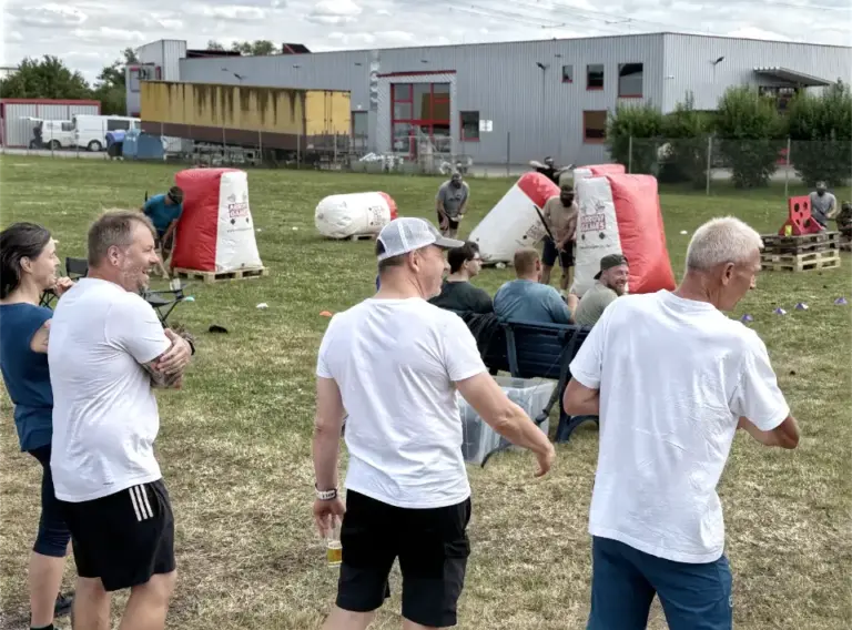 Firmenfeier mit Arrow Tag – Mobiles Outdoor-Event für Unternehmen Mitarbeitende verfolgen ein mobiles Arrow-Tag-Spiel während einer Firmenfeier mit spannenden Teamduellen auf einem Outdoor-Spielfeld