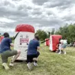 Mitarbeitende spielen Arrow Tag beim Outdoor-Teambuilding für Unternehmen und nutzen aufblasbare Hindernisse für spannende Teamduelle